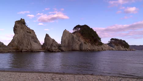 Locked-off-wide-view-of-ocean-and-tall-cliffs-on-partially-cloudy-day