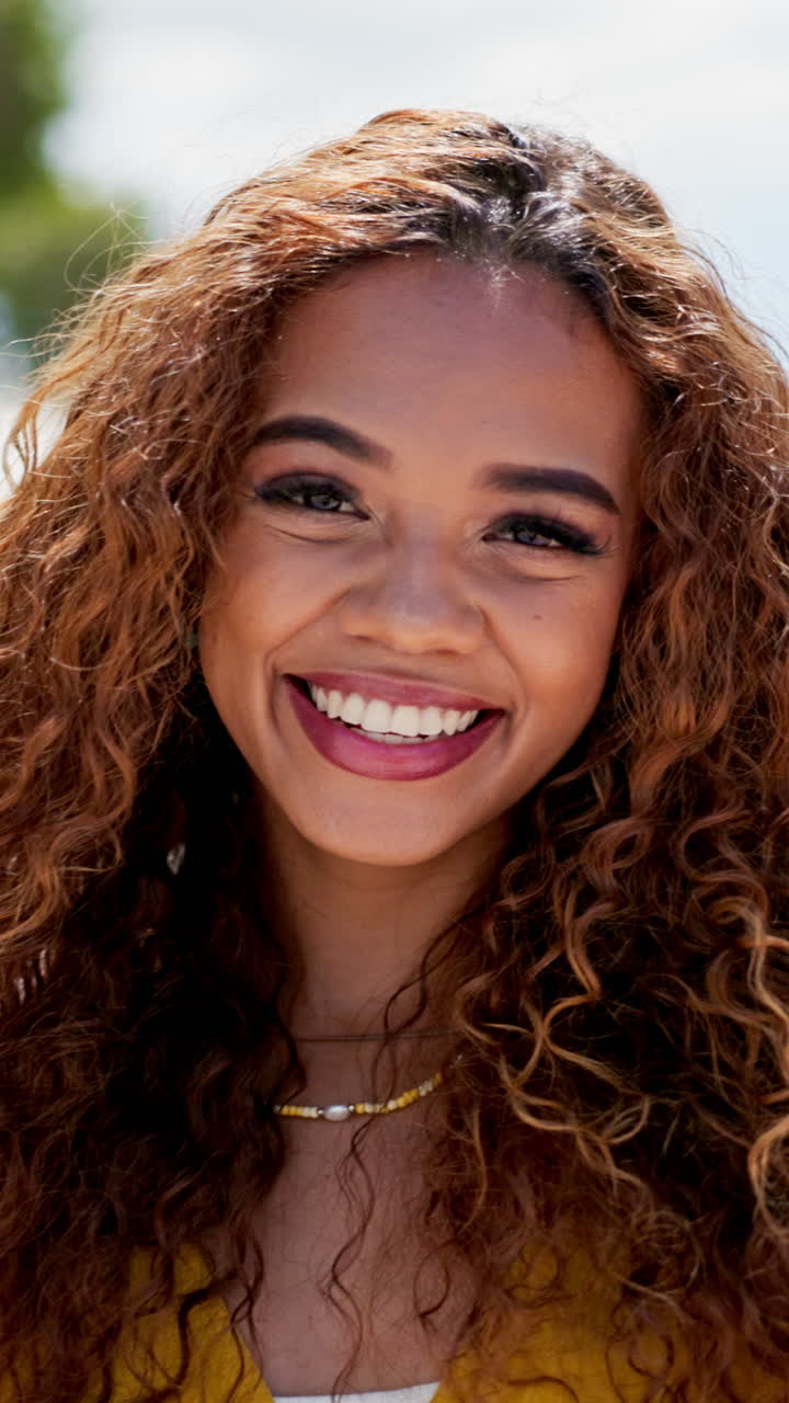 retrato de una mujer sonriente con el cabello rizado