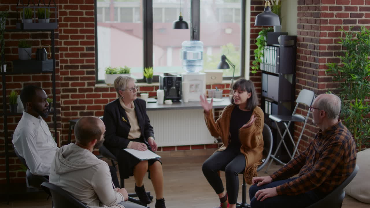 Angry woman explaining anger management problems at aa group meeting with psychiatrist