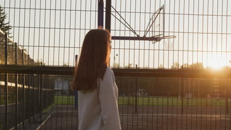 young lady enjoys sunset near stadium. lonely woman leisurely walks thinking about failure in competitions. dealing with negative emotions in fresh air