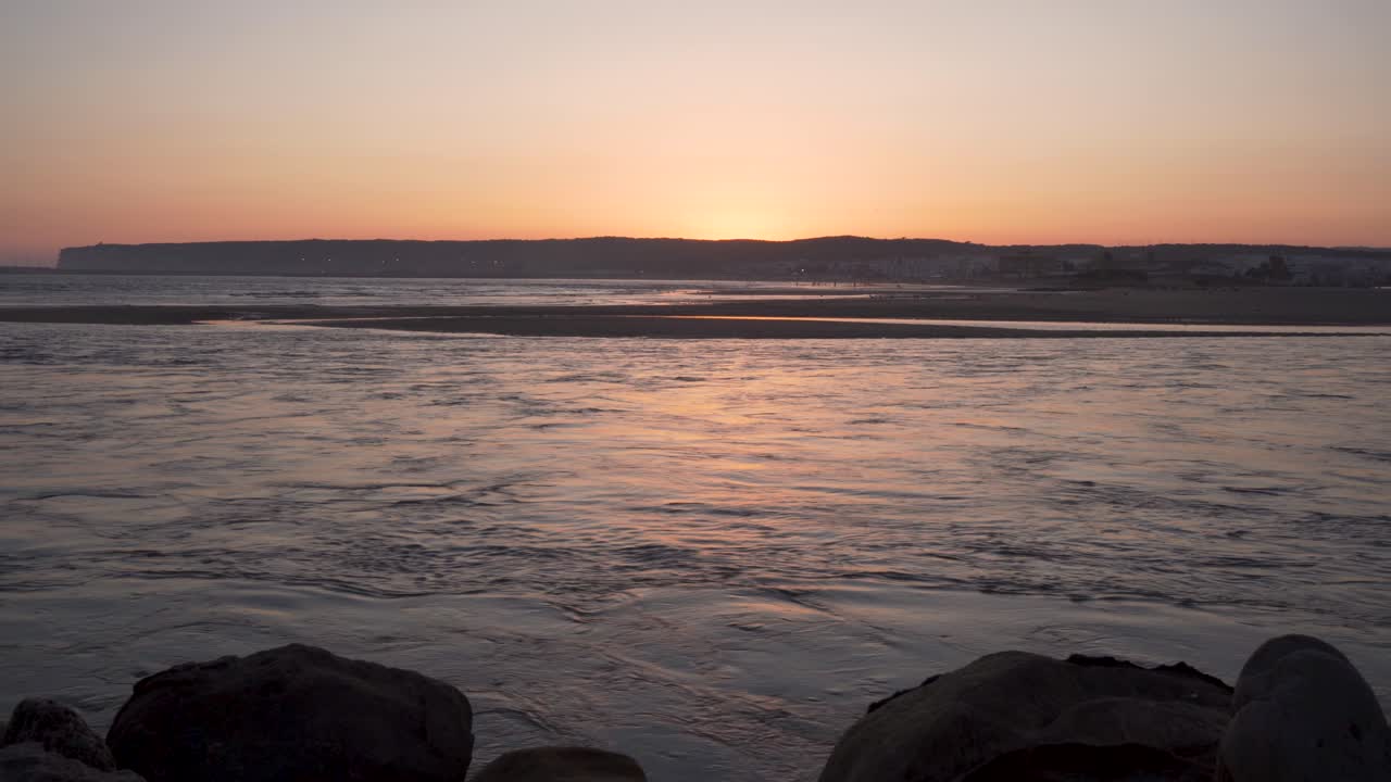 puesta de sol con la silueta de la montaña y gaviotas volando en barbate, españa