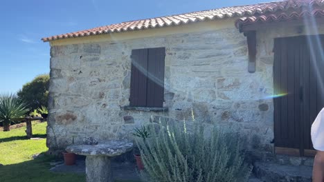 Woman-walking-out-of-a-beautiful-rural-mediterranean-house-hotel