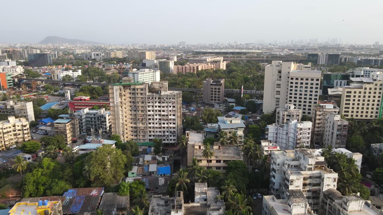 Ripresa drone: stazione metro Andheri Marol, Mumbai, India, vista a volo d'uccello, treno di lato, grandangolo su città verde