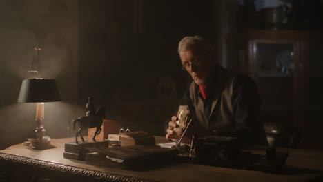older passionate man evaluates an old porcelain box