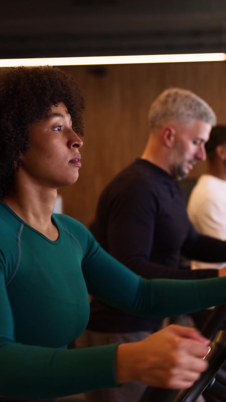 Diverse Group Exercising on Elliptical Machines in Modern Gym