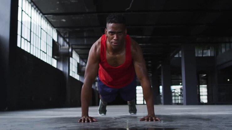 African american man doing push ups in an empty urban building