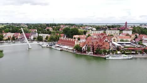 ciudad turística en warmian masurian con hermoso lago tranquilo en verano con yates y turistas, puentes y edificios históricos antiguos