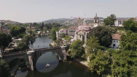 escénica toma aérea ascendente del puente histórico sobre el río tamega y la iglesia de sao goncalo junto al río