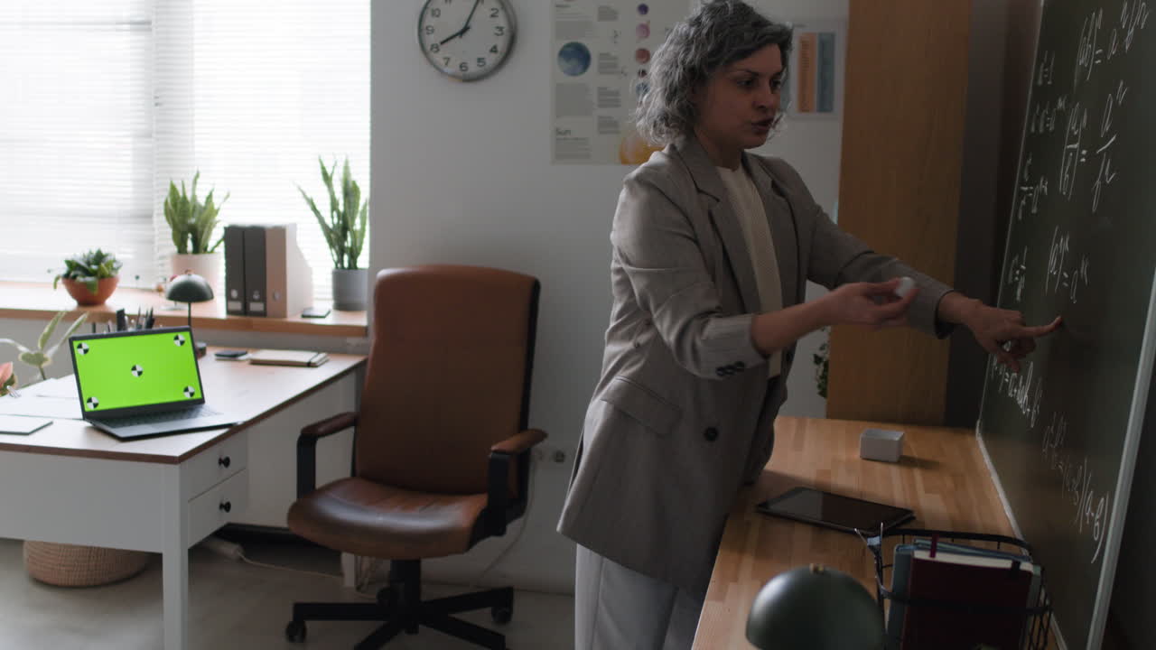 Teacher Explaining Math on a Blackboard