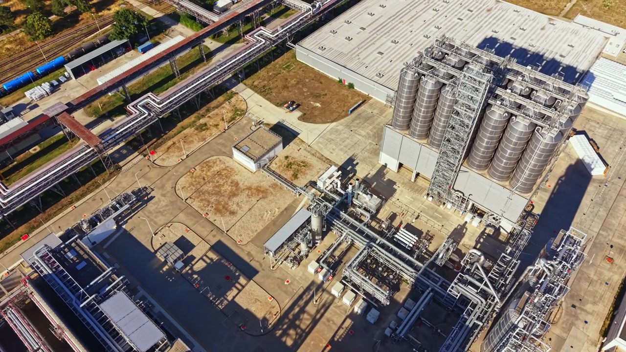 View of an industrial site with structures and pipelines in a large facility during daylight hours