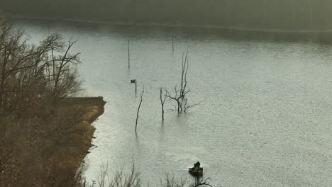 fisherman in a boat at lake swepco in arkansas, united states