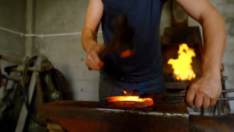 Metalsmith-molding-horseshoe-in-factory-4k