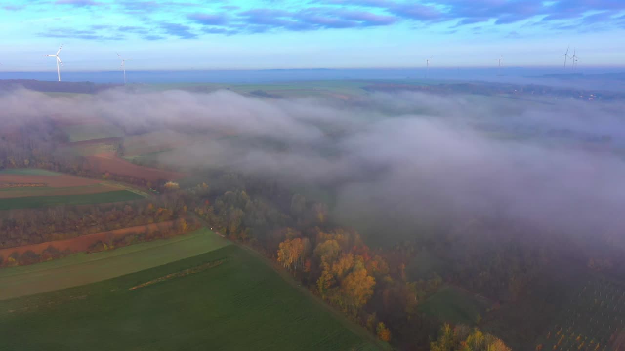 nubes nubladas sobre el paisaje natural otoñal y la turbina eólica al fondo