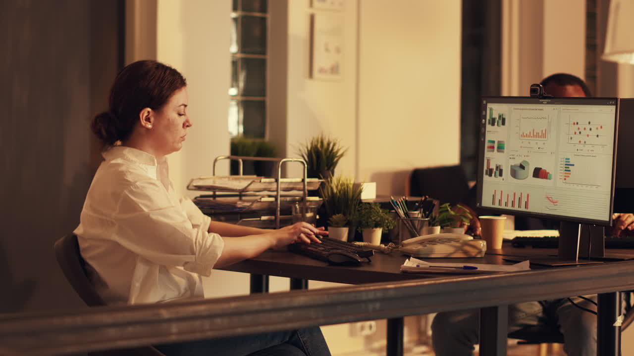 Office worker analyzing diagrams and charts on computer