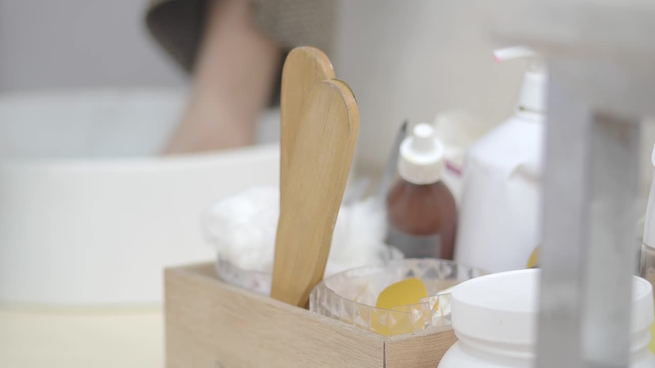 Primo piano di strumenti per spa con una persona che si immerge il piede sullo sfondo