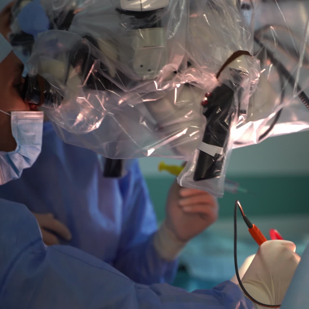 Neurosurgeon looking into the microscope and performs the operation. High-precise surgery using technological equipment
