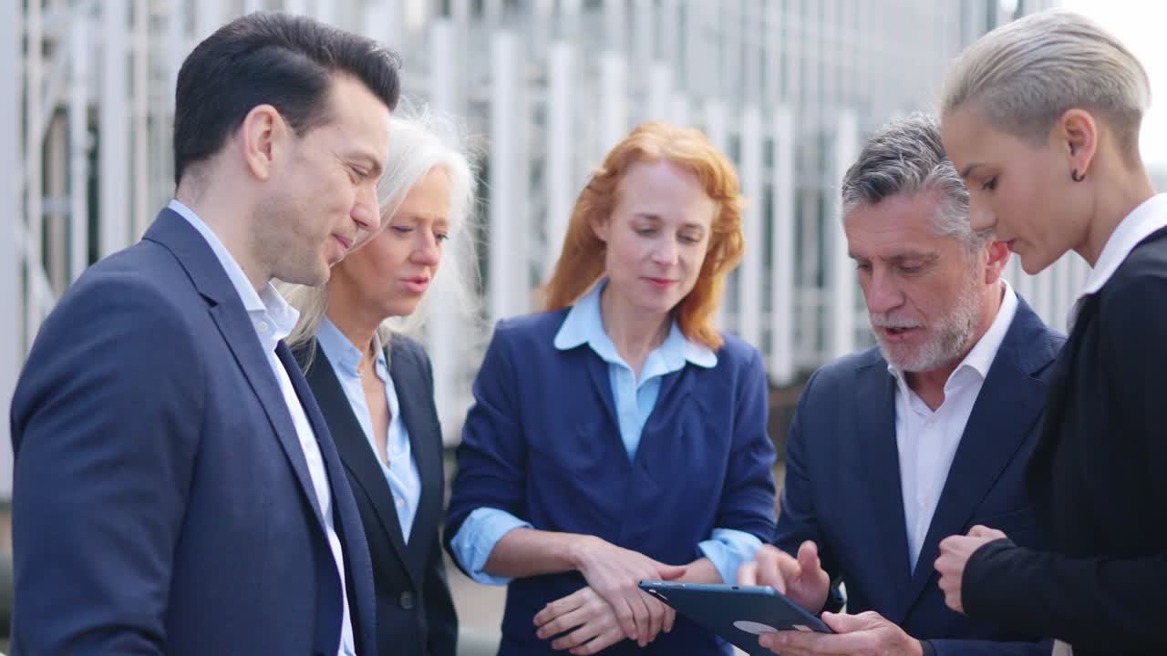 Business Professionals Discussing on a Tablet Outdoors