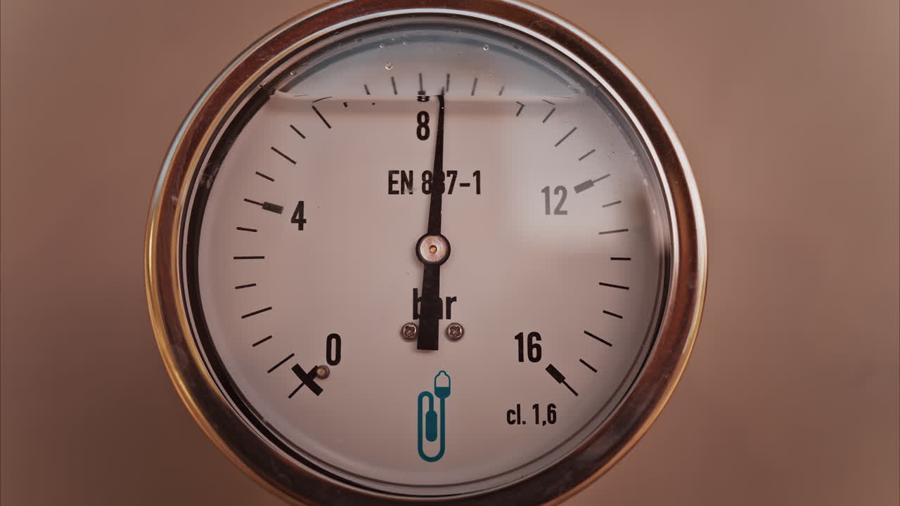 Close up of a circular pressure gauge with a metallic frame indicating the current pressure is 8 bar