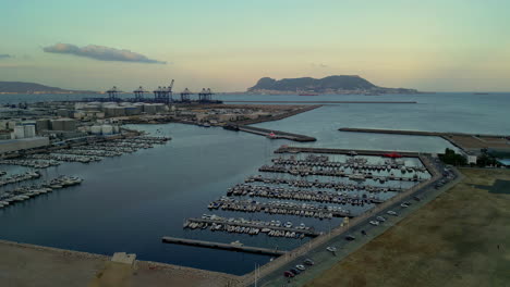 Pull-back-Drone-view-of-the-marina-at-Real-Club-Náutico-de-Algeciras,-Spain-at-twilight