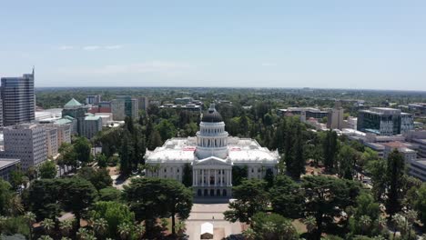 aerial wide reverse pullback shot of the california state capitol building in sacramento during the day