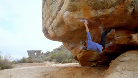 male hiker climbing rocky mountain in countryside 4k