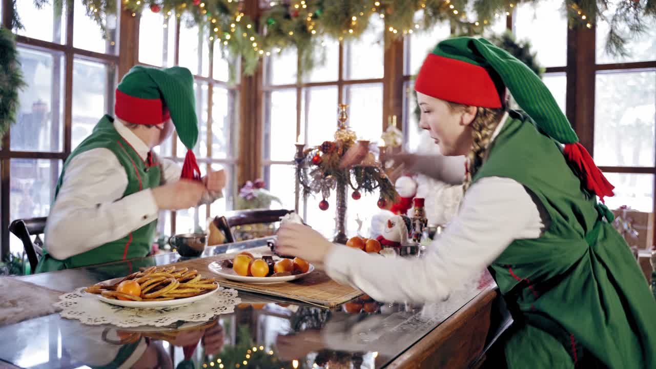 Happy Christmas At Dinner. Elves having fun during dinner at table