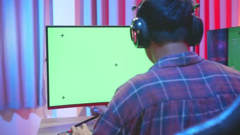 man gamer playing video game with green screen display