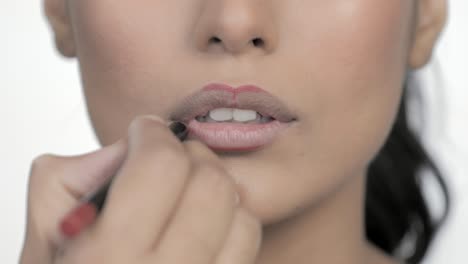 cosmetic makeup artist shaping lush lips with lipstick pencil product