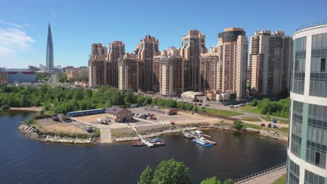 Aerial-Drone-shot-of-docked-boats-at-the-port-of-a-residential-building-compound-next-to-the-Western-High-Speed-Diameter,-Gulf-of-Finland-in-Saint-Petersburg,-Russia