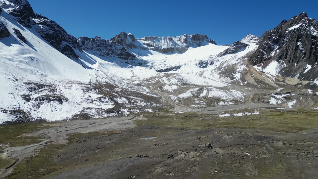 vuelo aéreo hacia picos de montañas nevadas en el altiplano de los andes, bolivia