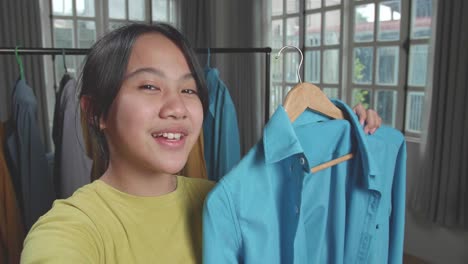 teenager trying on a blue shirt