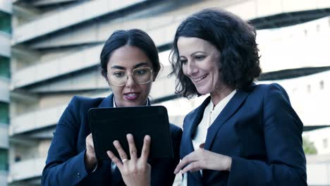 mujeres de negocios sonrientes con dispositivos digitales