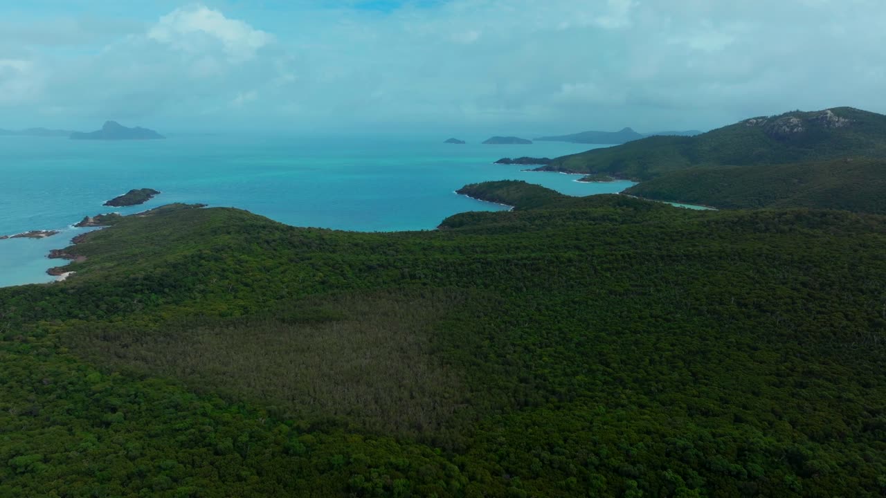 playa de whitehaven isla de whitsundays avión no tripulado aéreo sereno bush airlie parque nacional australia aus qld sol nublado cielo azul exterior gran barrera de arrecifes azul claro agua océano frente a la playa hacia adelante pan up movimiento