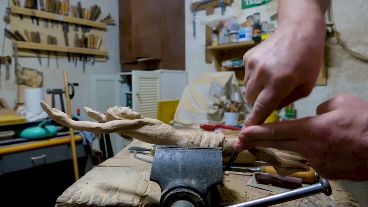 escultor italiano en su taller trabajando en una estatua de madera de olivo
