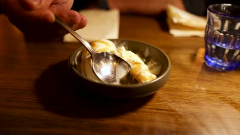 person eating ice cream with caramel sauce