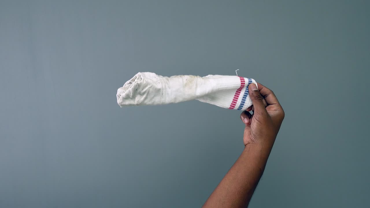 Dirty sock held in hand