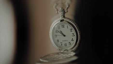 silver pocket watch moving in slow motion used to induce a state of hypnosis, close up shot