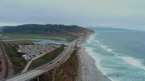 aerial flying backwards over torrey pines state beach on cloudy day