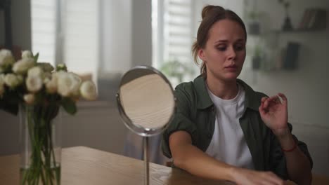 mujer preparándose frente a un espejo
