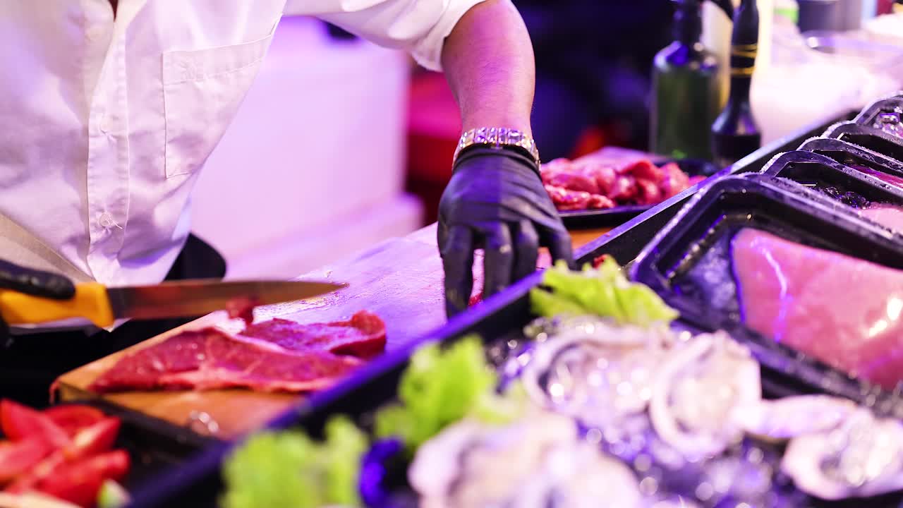 야간 시장 상점에서 고기를 잘라내는 셰프