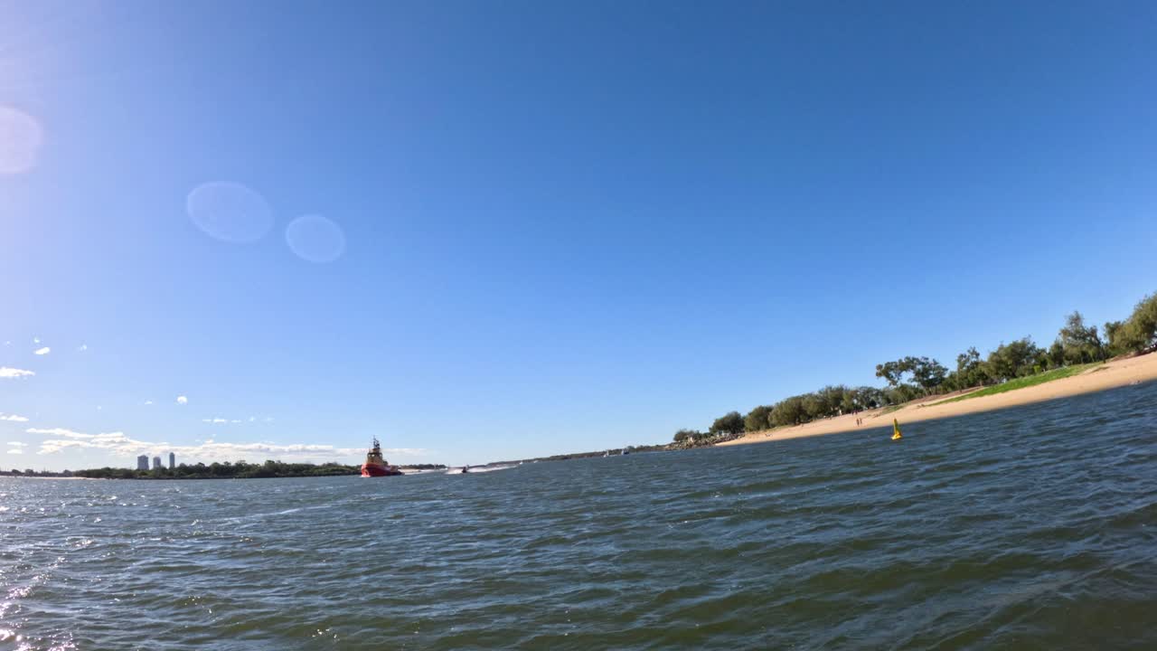 Sailboat gliding near Gold Coast shoreline