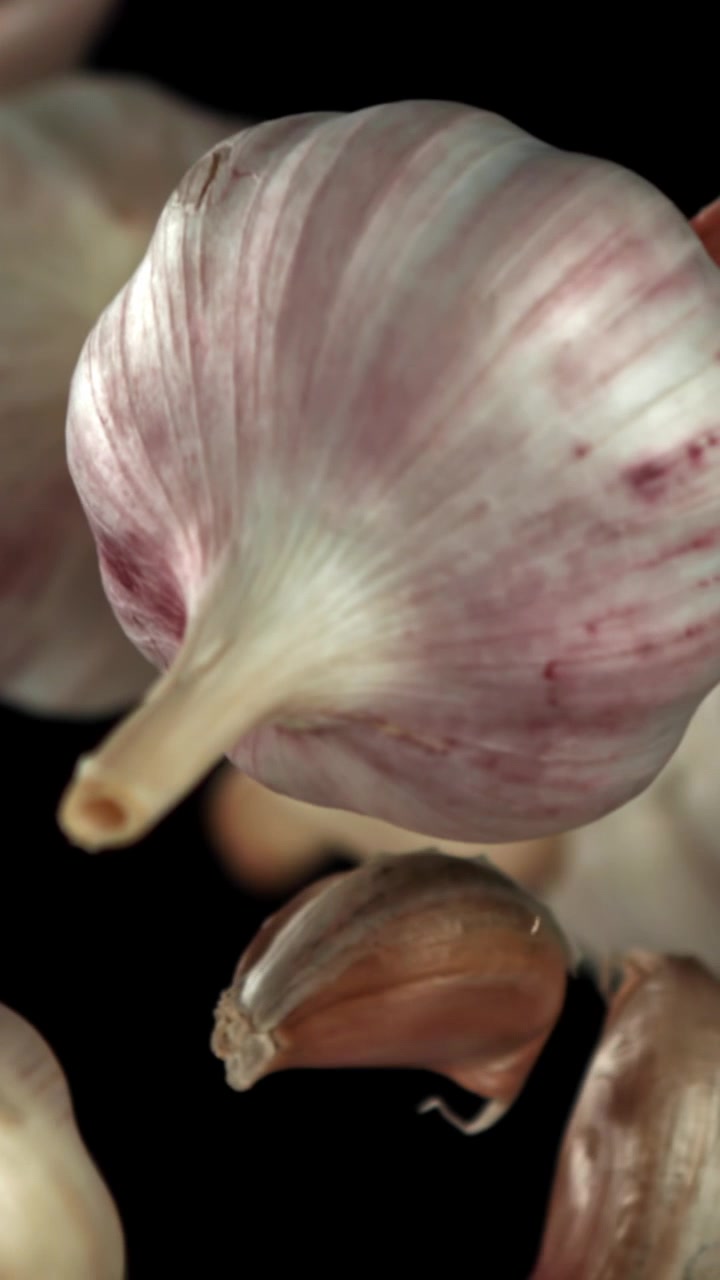 Primo piano di bulbi e spicchi d'aglio freschi su sfondo nero