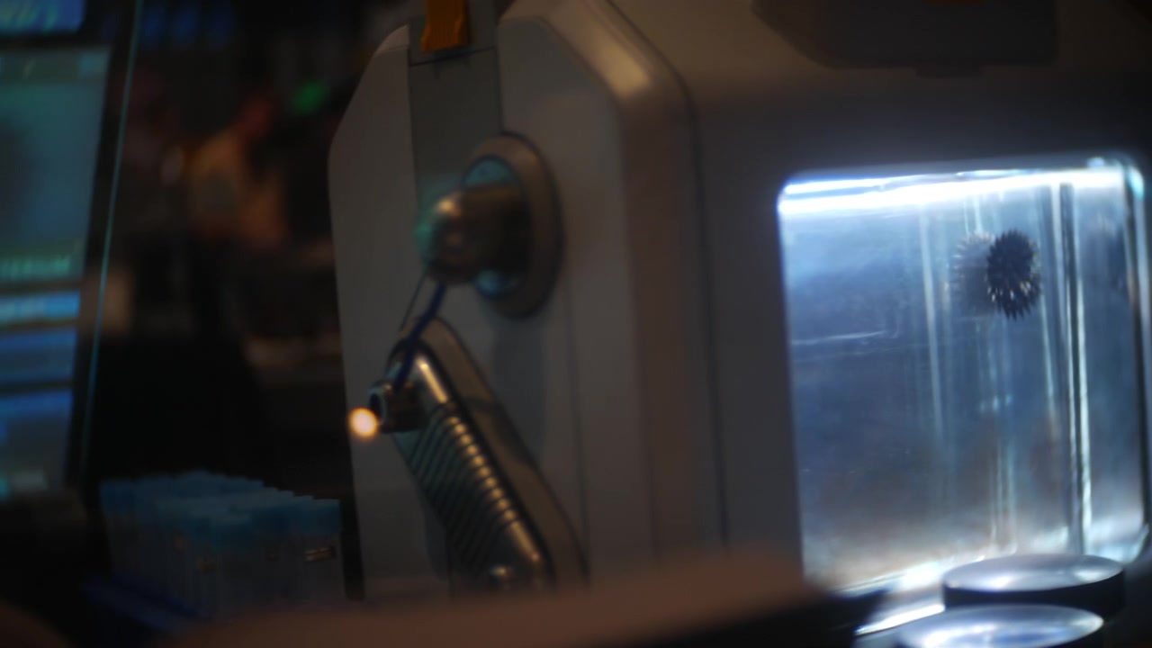 Machine module glowing beside medical tubes in a dark scientific laboratory. Close-up of illuminated biotech equipment operating in a futuristic research workspace