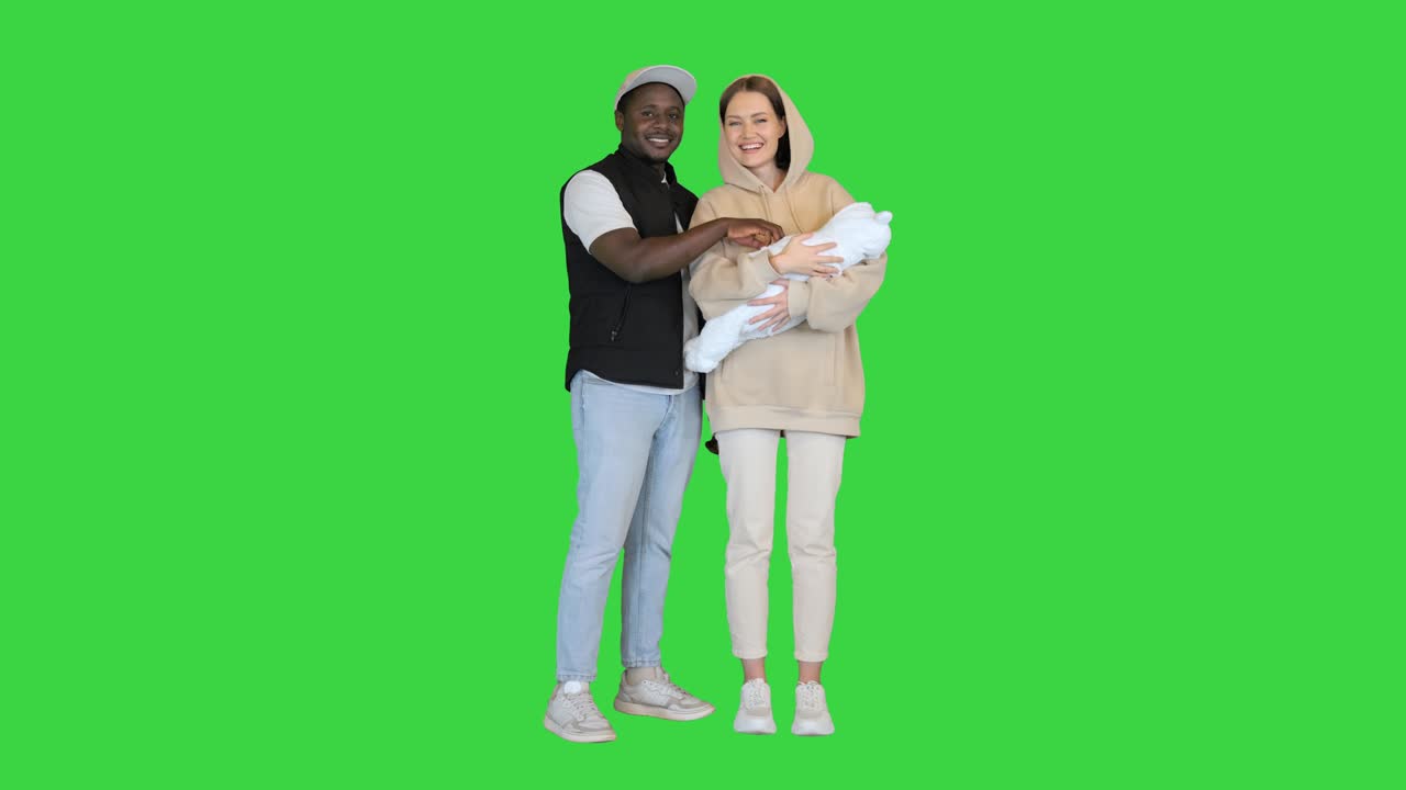 Casal inter-racial feliz segurando seu bebê em Tela Verde, Chroma Key