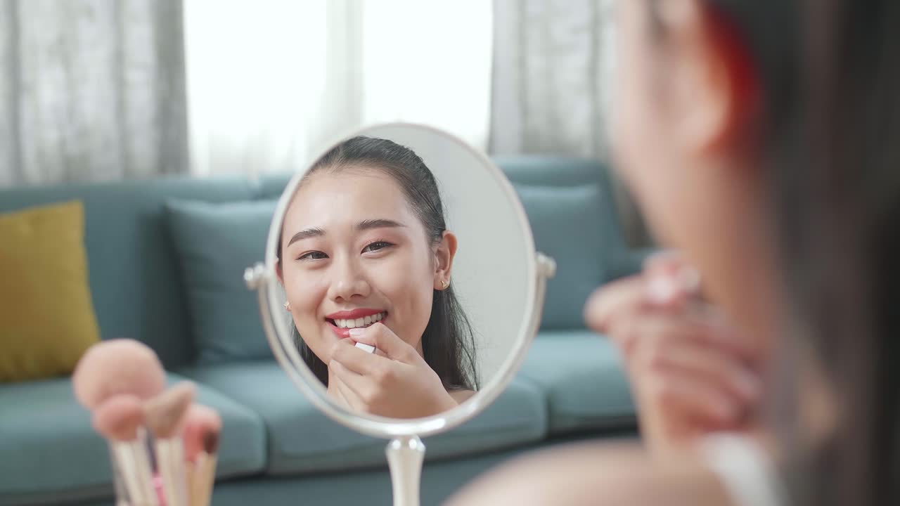 거울 앞 에서 립스틱 을 쓰는 여자