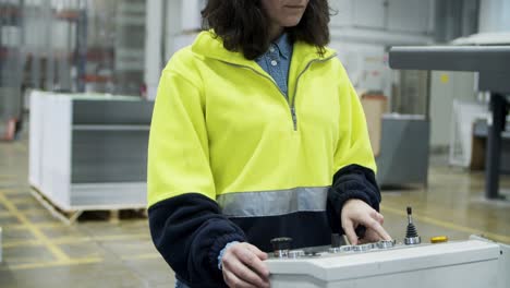 cropped view of female worker setting printing machine