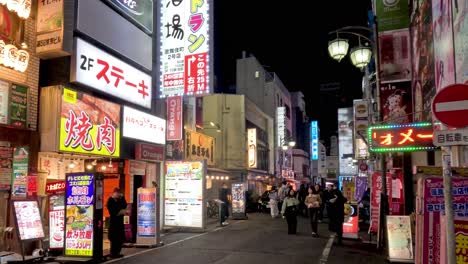 pedestrians walking through a vibrant neon-lit alley