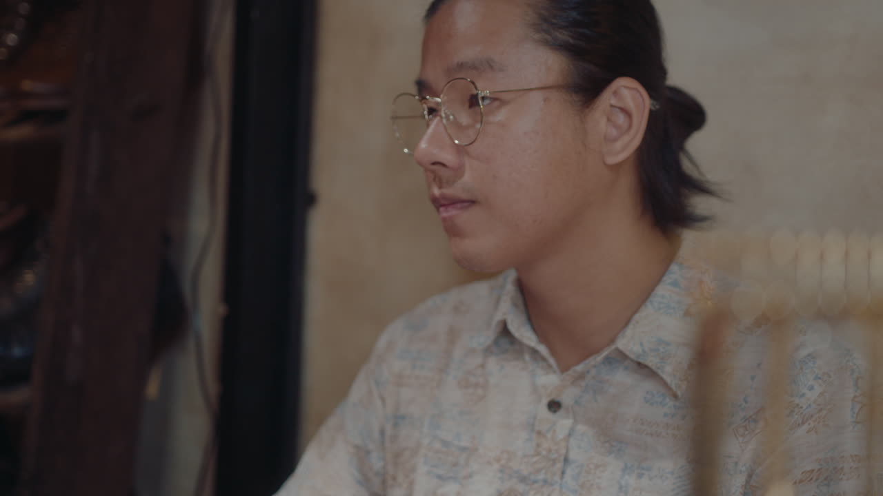 Young Asian Man Working on Computer in Pawn Shop