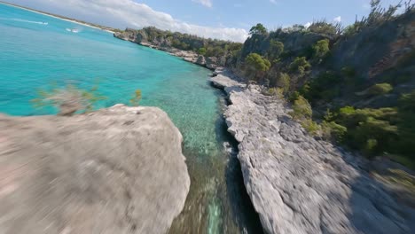 Aerial-racing-fpv-drone-view-along-rocky-coast-and-turquoise-sea-of-Cabo-Rojo-in-Dominican-Republic