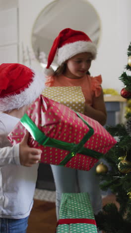 los hermanos sacuden los regalos de navidad para adivinar el contenido, encarnando el espíritu navideño familiar.